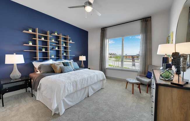 A bedroom with a large bed and a window overlooking a cityscape.