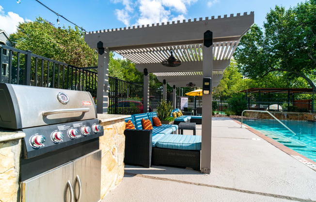 a backyard with a grill and a pool and a pergola