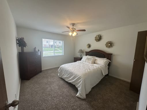a bedroom with a bed and a ceiling fan