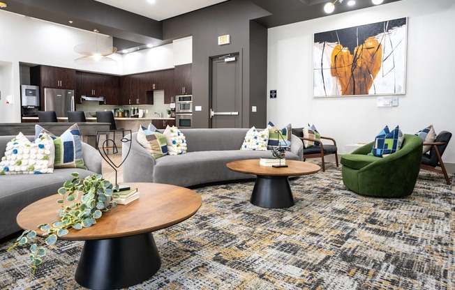 A modern living room with a grey sofa, a green armchair, and a wooden coffee table.