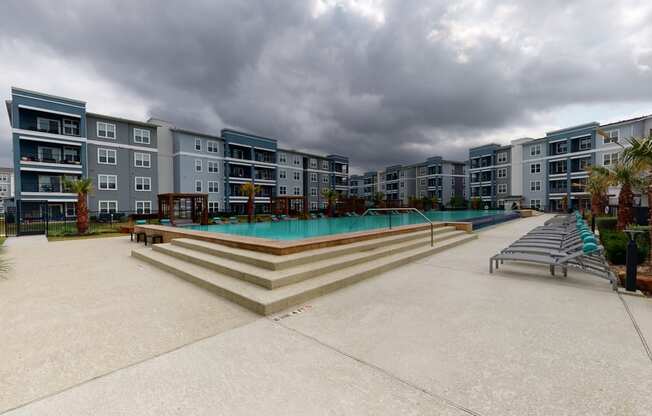 a large swimming pool in front of an apartment building