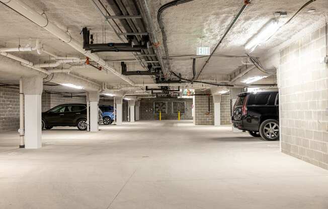 the underground parking garage of a building with parked cars