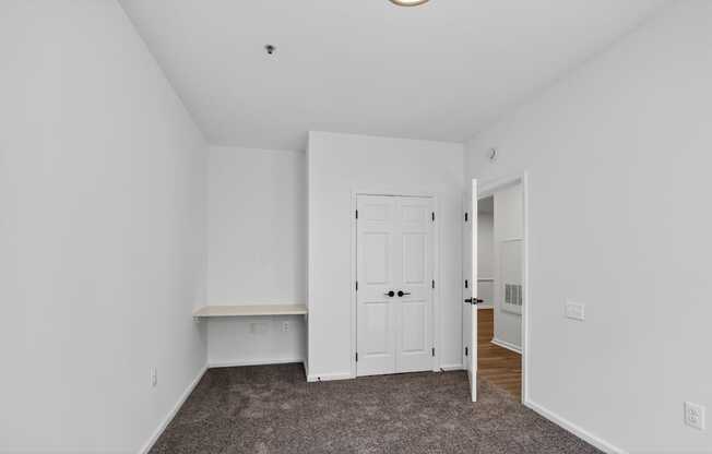 Renovated bedroom with carpeting and built in desk