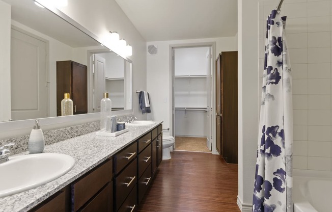 a bathroom with a sink and a mirror and a shower curtain