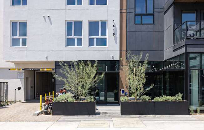 A modern building with a white and grey facade and a black door at Skylar At Sunset Apartments, Los Angeles, California
