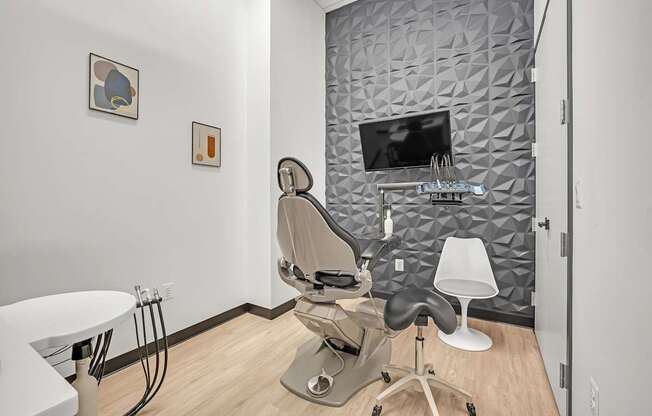 A modern hair salon with a grey patterned wall and a white chair.
