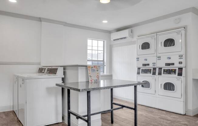 a washer and dryer in a laundry room with a table