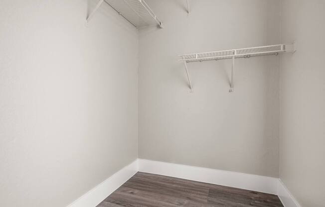Empty room with a shelf and wooden floor.