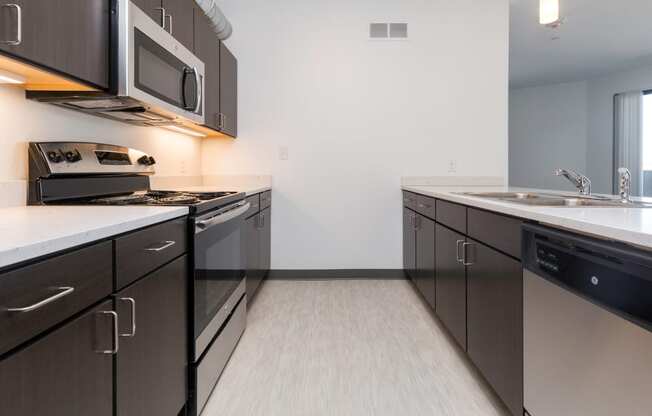 Modern open-concept kitchen and living area with stainless steel appliances.