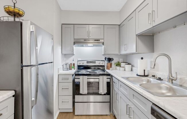 A modern kitchen with white appliances and cabinets. at The Beacon, Alabama, 35816