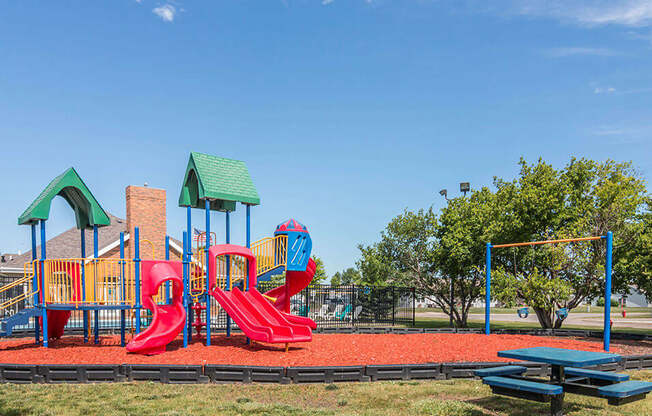 a playground with a picnic table and picnic table in front of it