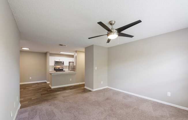 Model living room with ceiling fan and carpet at Fountains at Lee Vista in Orlando, Florida.
