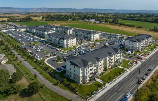 an aerial view of an apartment complex with cars parked in a parking lot