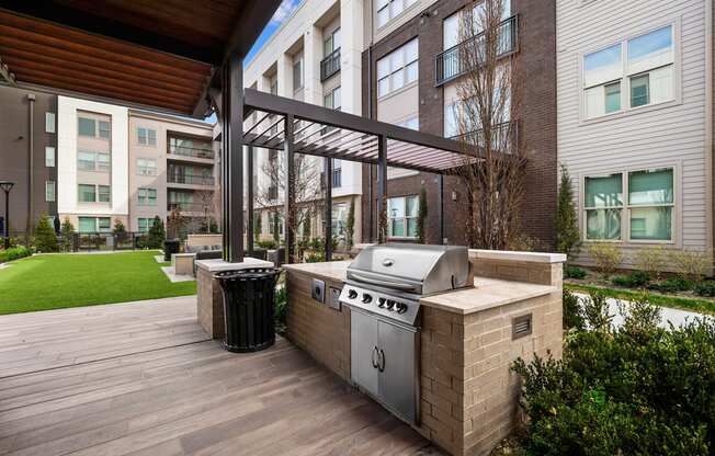 a barbecue grill on a deck in front of an apartment building