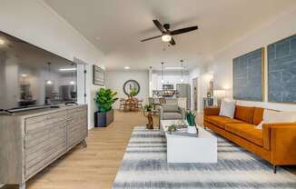 A modern living room with a kitchen area in the background.