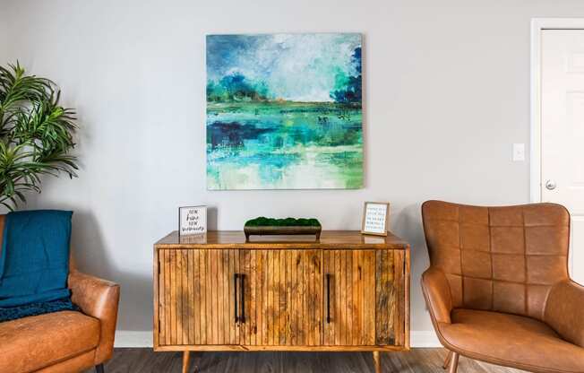 a living room with a cabinet and a painting on the wall