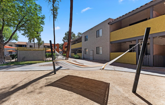 a hammock is hung on a pole in a courtyard at the whispering winds apartments in pear