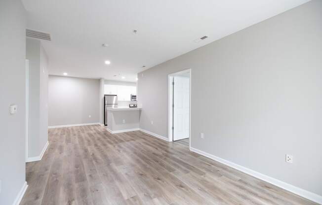 a living room with a hard wood floor and white walls