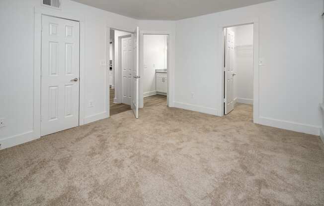 A bedroom with carpeted floor, bathroom and walk-in closet
