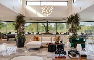 the lobby of a hotel with a couch and chairs and large windows at Esplanade District Apartments, Little Rock, AR,72114