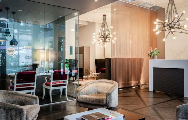 a lobby with chairs and a table and a chandelier