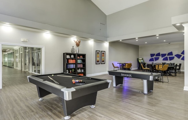 Community clubhouse with a pool table, air hockey table, poker tables and vintage arcade machine.