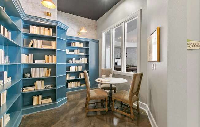 A room with a table and chairs and a bookshelf at Prairie Crossing, Farmers Branch, 75244