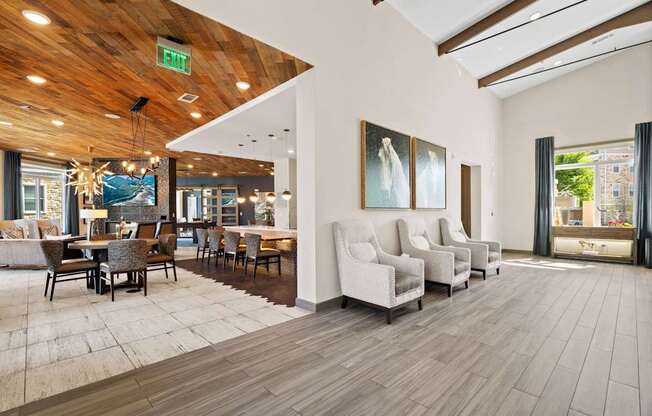 A room with a wooden ceiling and floor, a white couch, and a painting on the wall.