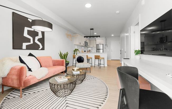 a living room with a pink couch and a black and white rug at Ion Town Center, Washington