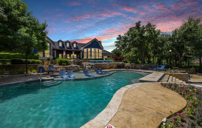 a swimming pool with a house in the background at sunset at The Vista on Brodie, Texas, 78745