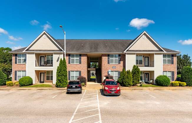 the view of an apartment building with two cars parked in front of it