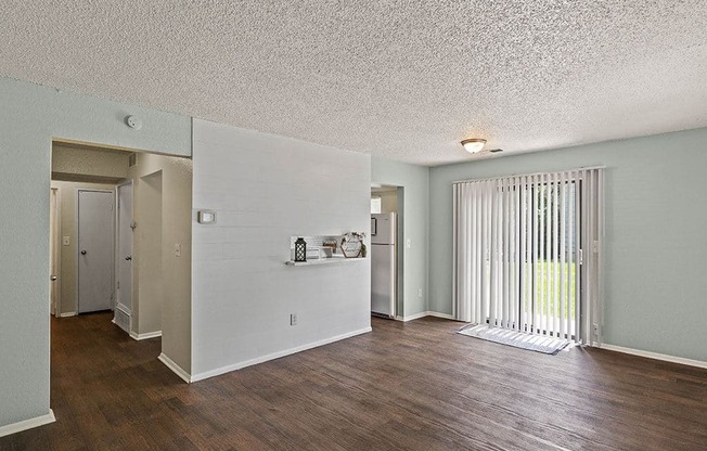 a living room with a wood floor and a sliding glass door