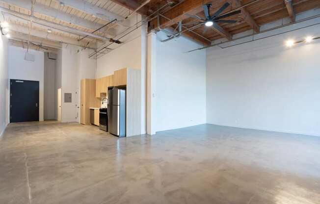 an empty room with a refrigerator in the middle of it