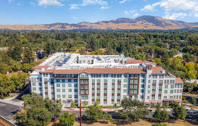 Aerial view of a modern Mediterranean-inspired apartment community with Mt. Diablo in the backdrop
