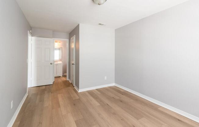 A long hallway with wood floors and white walls.