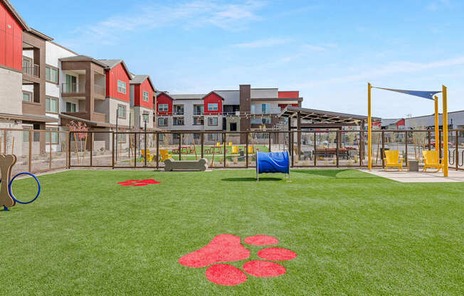 A playground with a blue tarp and red flower pattern on the grass.
