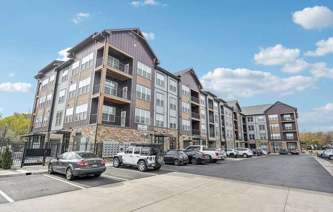 a large apartment building with cars parked in a parking lot at The Quarry Luxury Apartment Homes, Colorado