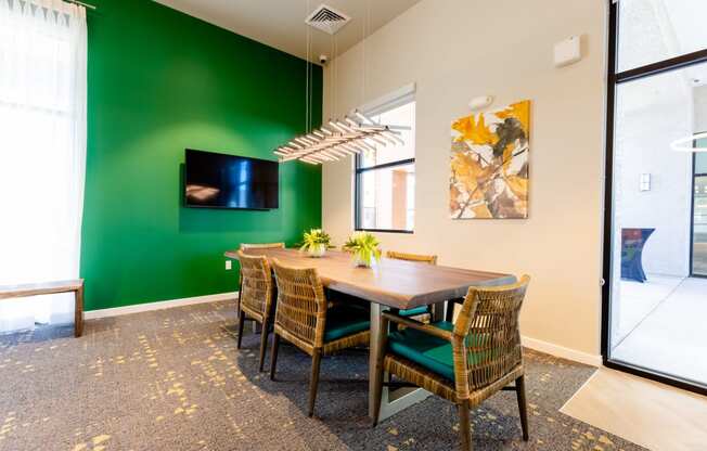 a dining room with a table and chairs and a green wall