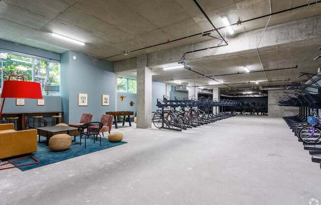 A room with a red lamp, chairs, and bicycles.