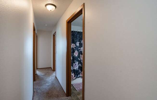 a hallway with a closet and a mirror in a house. Fargo, ND Westview Towers Apartments