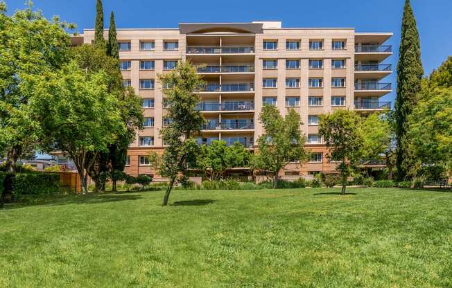 A large grassy area in front of a multi-story building.