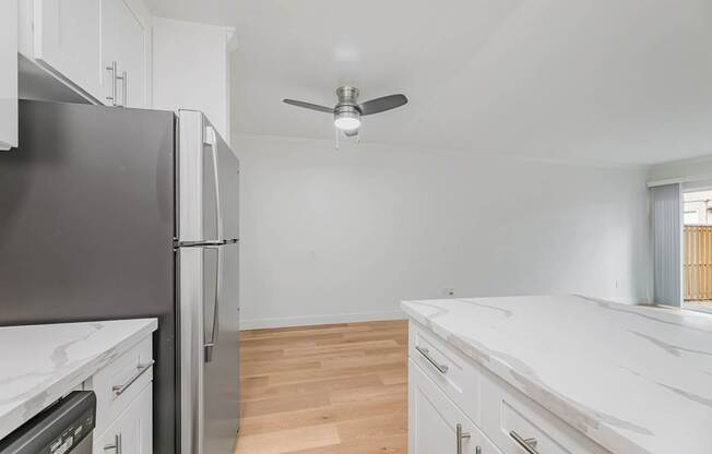 A kitchen with a black fridge and white cabinets.