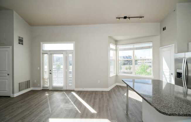 an empty living room with a large window and a table