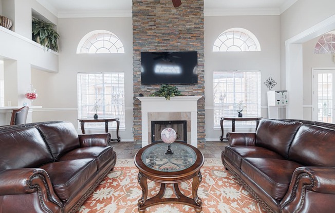 a living room with leather couches and a fireplace