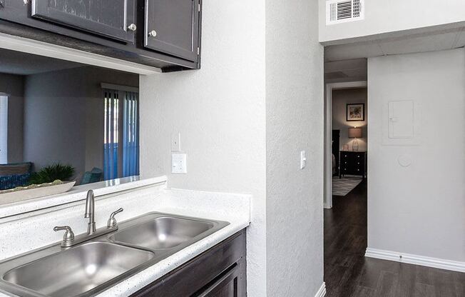 a kitchen with a sink and a window and a hallway