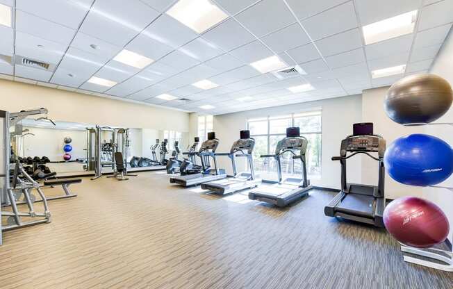 fitness center with exercise balls, cardio machines and large windows at archer park apartments in southeast Washington dc