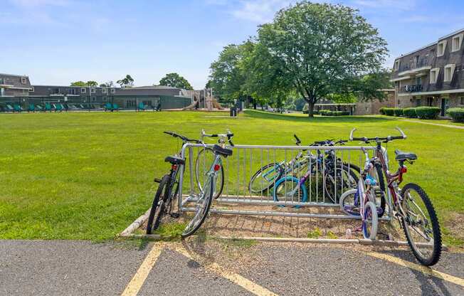 A bike rack with several bicycles parked in front of a building.