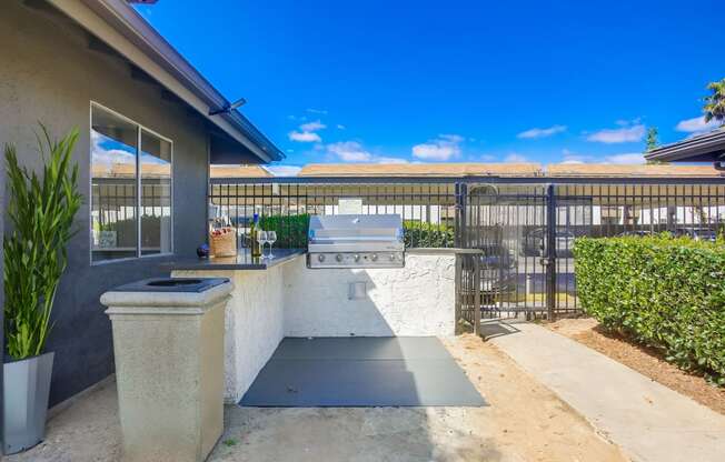 the backyard has an outdoor bar with a grill and a fence