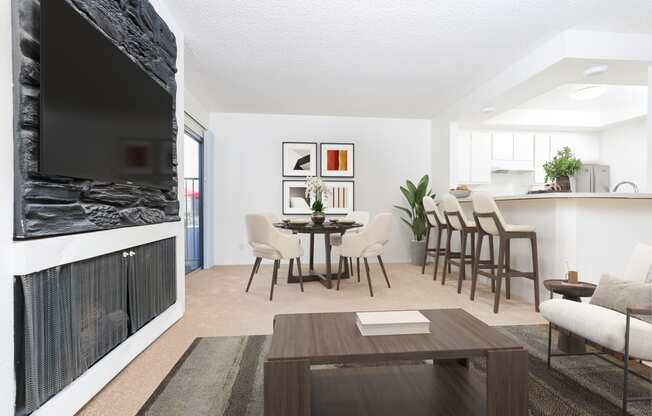 a living room and dining room with a table and chairs