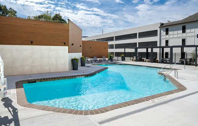 A small pool with a brown wall and a white wall behind it.